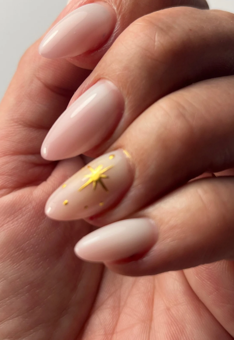 Manucure élégante avec motif étoilé doré, réalisée à l'institut de beauté toute Belle d'Alfortville, France.